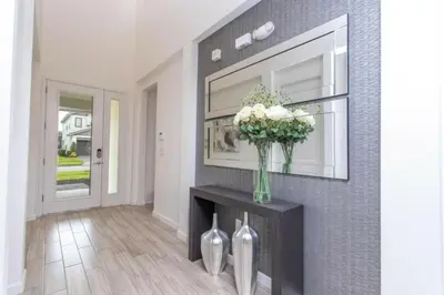 a living room with a fireplace and a vase of flowers at Luxurious Home Private Pool 2693 in Kissimmee