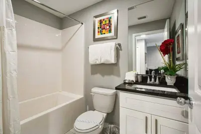 a bathroom with a toilet and a sink and a tub at 4412 Luxurious Townhome Private Pool in Kissimmee