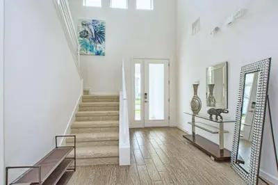 a white hallway with stairs and a mirror at 2600YA Luxury Gorgeous Private Pool in Kissimmee