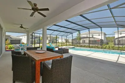 a conservatory with a table and chairs and a pool at 2600YA Luxury Gorgeous Private Pool in Kissimmee