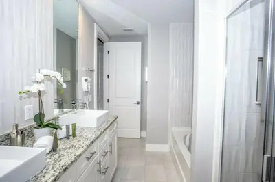a white bathroom with two sinks and a tub at 2620 Magical Memories 15 min-Disney in Orlando