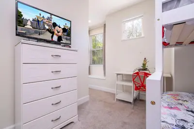 a bedroom with a dresser with a flat screen tv at 17419 Awesome Modern w Private Pool in Orlando