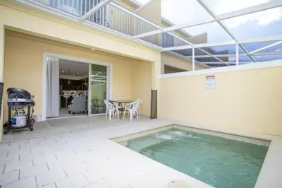 a swimming pool in a patio with a table at 17419 Awesome Modern w Private Pool in Orlando