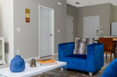 a living room with a blue chair and a table at Cozy 3 bedroom home with Private Pool 4564 in Kissimmee