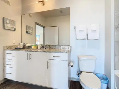 a bathroom with a toilet and a sink and a mirror at Your Dream Apartment Stay in Kissimmee