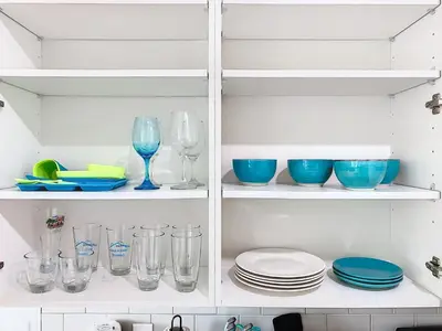 a cupboard filled with plates and bowls and glasses at Your Dream Apartment Stay in Kissimmee