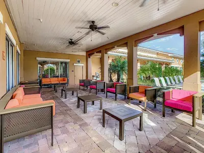 a patio with colorful chairs and tables and windows at Your Dream Apartment Stay in Kissimmee