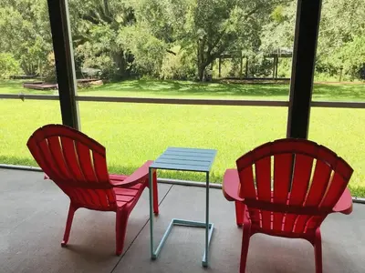 two chairs and a table in front of a window at Hidden City Riverfront Apt Near Lakes Golf & Disney in Kissimmee
