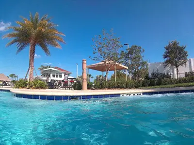 a swimming pool with blue water in front of a house at Triple Header Storey Lake By Shine Villas #700 in Kissimmee