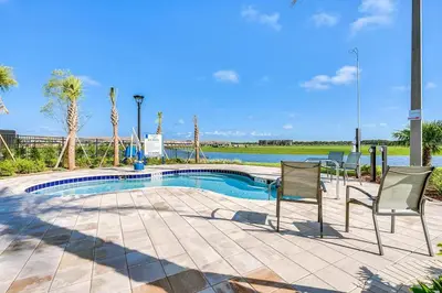 a swimming pool with two chairs and a table at Triple Header Storey Lake By Shine Villas #700 in Kissimmee