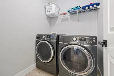a laundry room with a washing machine and a drying rack at Walkin' on Sunshine - 5 bed pool home in Terra Verde Resort near Disney in Kissimmee