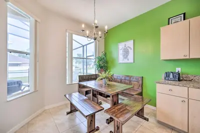 a dining room with a table and chairs and a green wall at Dog-Friendly Kissimmee Home with Lanai and Pool! in Kissimmee