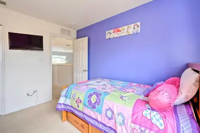a bedroom with a bed with a purple wall at Dog-Friendly Kissimmee Home with Lanai and Pool! in Kissimmee