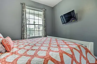 a bedroom with a bed and a flat screen tv at 6 Mi to Disney World Condo with Community Perks! in Kissimmee