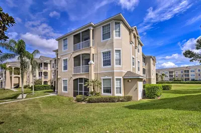 a large apartment building with a lawn in front of it at 6 Mi to Disney World Condo with Community Perks! in Kissimmee