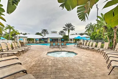 a courtyard with chairs and a pool with a swimming pool at 6 Mi to Disney World Condo with Community Perks! in Kissimmee