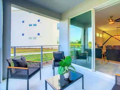 a balcony with chairs and a table with a plant at Homely Lakeview 3BR Condo with Waterpark in Kissimmee
