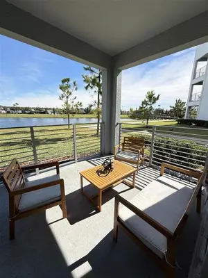 a porch with two beds and a table and chairs at Homely Lakeview 3BR Condo with Waterpark in Kissimmee