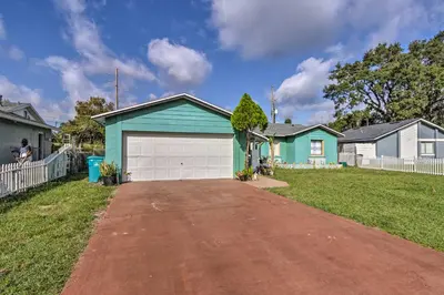 a blue house with a garage in a yard at about 9 Mi to Universal Orlando Retreat with Sun Porch! in Orlando