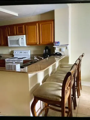 a kitchen with a row of chairs at a counter at Disney 1 mile , Blue Heron 1 room 2 bath,amenities,6 guests, walk to restaurants, no fees at check in in Orlando