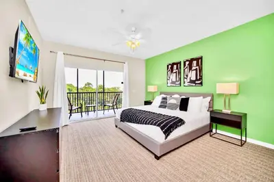 a bedroom with green walls and a bed and a balcony at Upstay - Pet-Friendly Suite w Pool, Sauna in Orlando