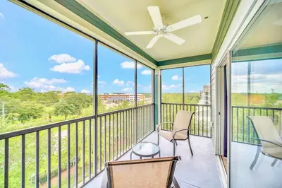 a balcony with two chairs and a ceiling fan at Upstay - Pet-Friendly Suite w Pool, Sauna in Orlando