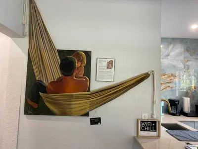 a painting of a man in a hammock on a wall at Bella Breeze in Sanford