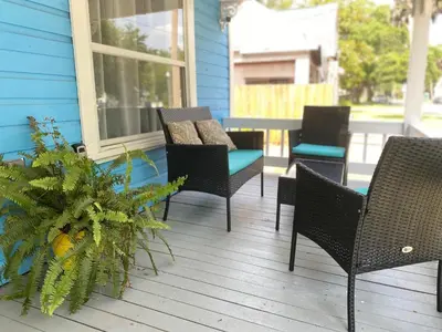 a porch with chairs and a table and a plant at The Blue Aztec in Sanford