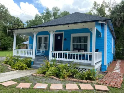 a blue tiny house with a white porch at The Blue Aztec in Sanford