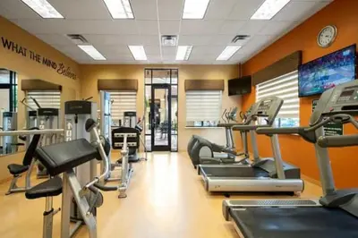 a gym with several treadmills and cardio machines at Designer Corner Suite 3BR/2BA -Disney & Universal in Orlando