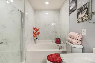 a bathroom with a tub and a toilet and a sink at Chic Orlando Family Getaway with Fenced Yard! in Orlando
