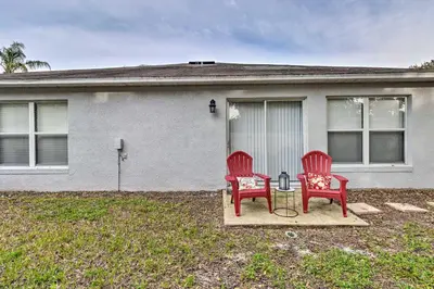two red chairs sitting in front of a house at Chic Orlando Family Getaway with Fenced Yard! in Orlando