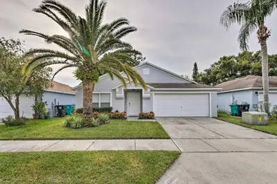 a house with a palm tree and a driveway at Chic Orlando Family Getaway with Fenced Yard! in Orlando
