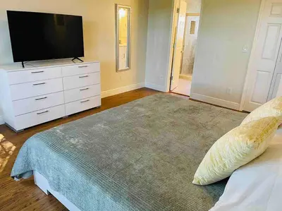 a bedroom with a large bed with a flat screen tv at Luxury • Modern • CLOSE2DISNEY • 3bed • 2bath in Kissimmee