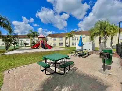 a park with two picnic tables and a playground at Luxury • Modern • CLOSE2DISNEY • 3bed • 2bath in Kissimmee