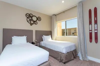two beds in a room with snowboards on the wall at 4 Suites - 5 min from Disney - w Jacuzzi 7557 in Orlando