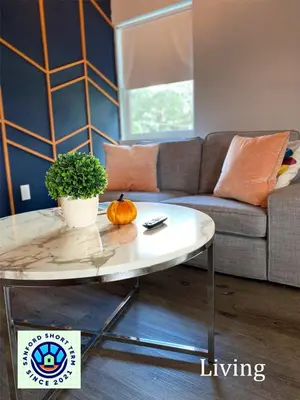 a living room with a table and a couch at The Contemporary in Sanford