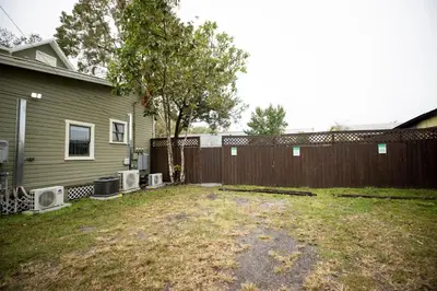 a yard with a fence next to a house at The Contemporary in Sanford