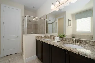 a bathroom with two sinks and a large mirror at Encore Resort 11 Bedroom Home with Pool 2206 in Orlando