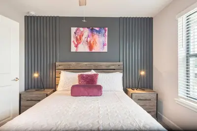 a bedroom with a large bed with a pink pillow at 3BR Resort Pool Jacuzzi Minutes to Disney 4730 in Kissimmee