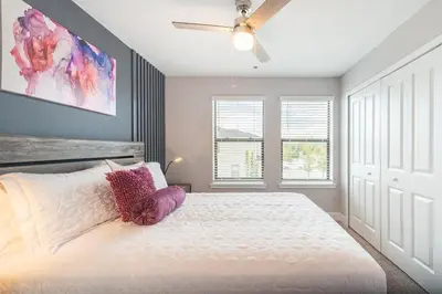 a bedroom with a white bed with a ceiling fan at 3BR Resort Pool Jacuzzi Minutes to Disney 4730 in Kissimmee