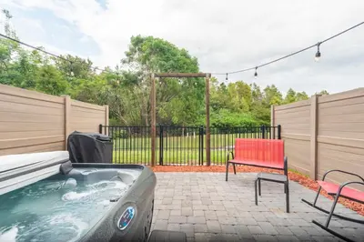 a hot tub in a backyard with a red chair at 3BR Resort Pool Jacuzzi Minutes to Disney 4730 in Kissimmee