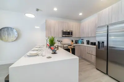 a kitchen with a white counter and a refrigerator at Private Pool Villa Family Retreat Near Disney World in Orlando
