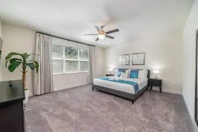 a bedroom with a bed and a ceiling fan at Private Pool Villa Family Retreat Near Disney World in Orlando