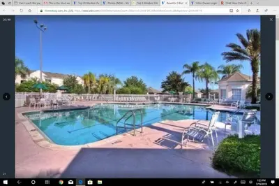 a large swimming pool with chairs and a table at Veteran Owned 3bdr/3 bath Townhouse w/WiFi 3mi to Disney - Fall/Winter Specials in Kissimmee