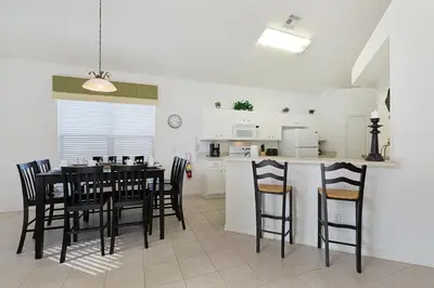 a kitchen and dining room with a table and chairs at Windsor Dream - 6 bedroom resort pool home in Orlando