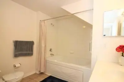 a white bathroom with a tub and a toilet at Family Friendly 3BR near Disney in Kissimmee