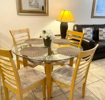 a dining room table with four chairs and a lamp at Family Friendly 3BR near Disney in Kissimmee