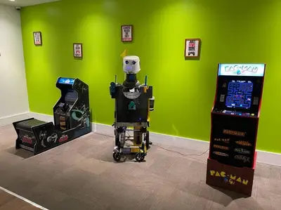 a robot standing next to a video game machine at Newly Room in cozy hotel with Super location to the Parks in Kissimmee