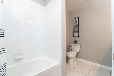 a white bathroom with a toilet and a bath tub at Resort Near Disney FREE Waterpark 4741 in Kissimmee